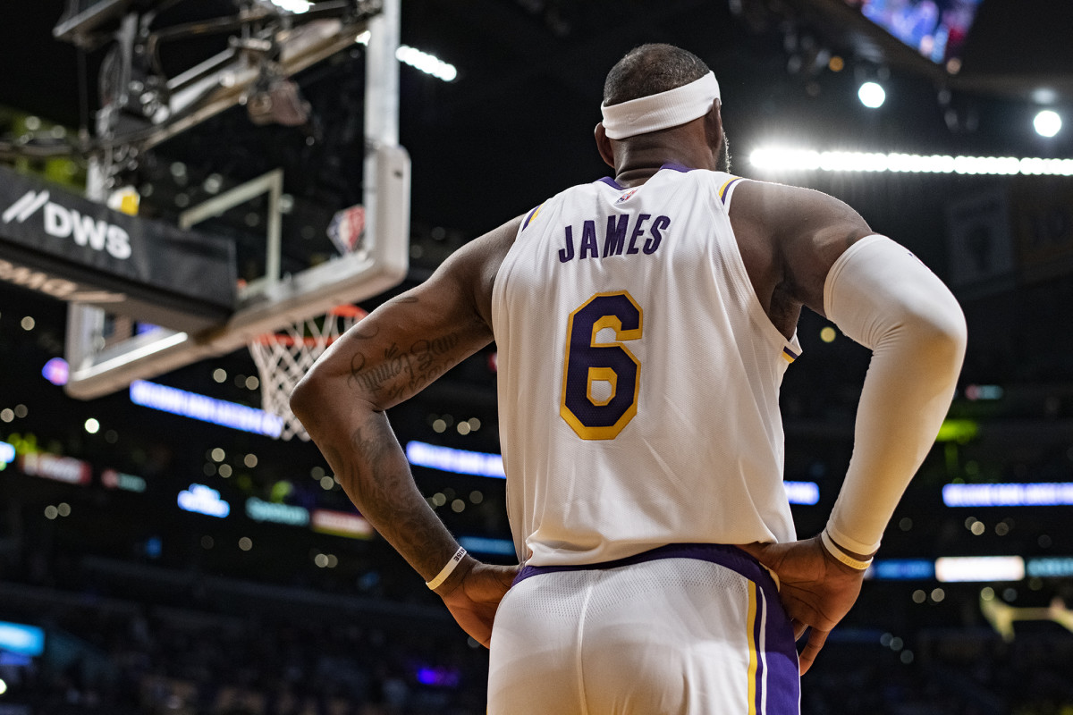 The back of LeBron James, with his name and number on his jersey, as he stands with his hands on his hips